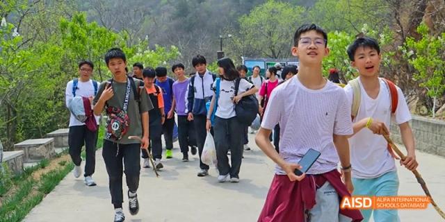 A group of students walking together outside on a sunny day at Beijing Hui Xian School.