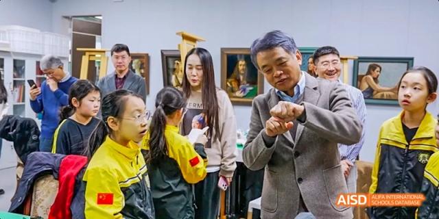 A group of students at Beijing Huijia Private Shool is seated at a table, focused on their work.