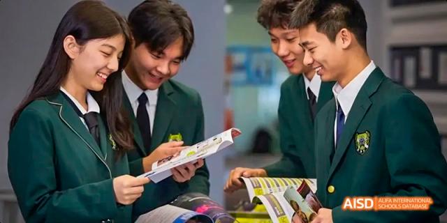 Two students from Beijing Huijia Private School read books together in a classroom.