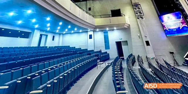 A wide shot of the auditorium at Beijing Huijia Private School, with rows of empty seats.