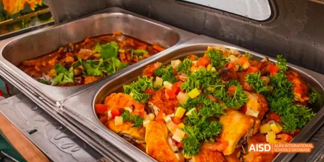 A serving dish from the buffet line at Beijing Huijia Private School, filled with a colorful and fresh stir-fried vegetable and meat dish.