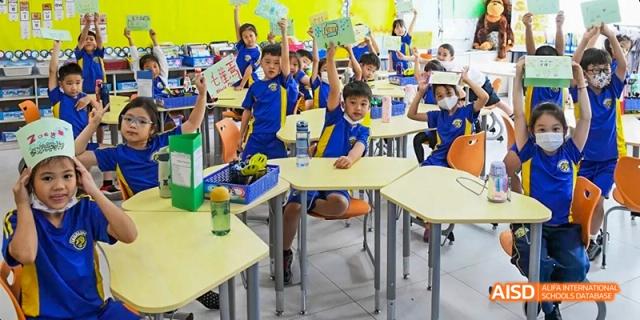 A group of students smiling and posing in a bright classroom at Beijing International Bilingual Academy.