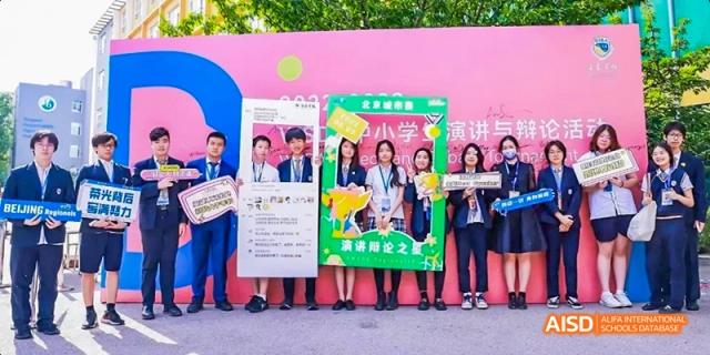 A group of students holding a banner and posing for a photo at Beijing International Bilingual Academy.