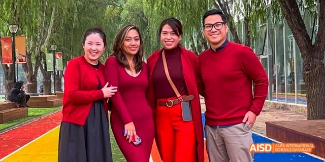 A group of people in red outfits posing for a group photo at Beijing International Bilingual Academy.