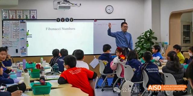 A teacher writing on a whiteboard in a classroom of students at Beijing International Bilingual Academy.