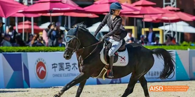 A person riding a horse during an equestrian event at Beijing International Bilingual Academy.