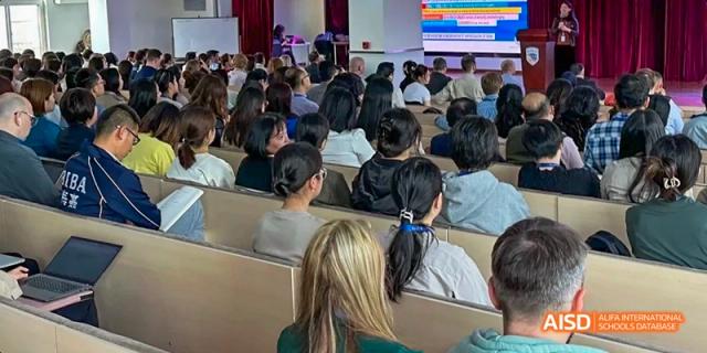An audience of people listening to a presentation at an event at Beijing International Bilingual Academy.