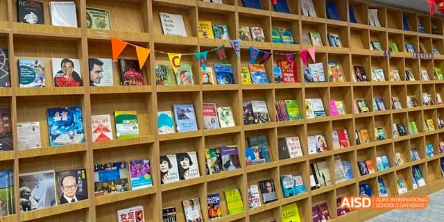 A bookshelf filled with a variety of books in the library at Beijing International Bilingual Academy.