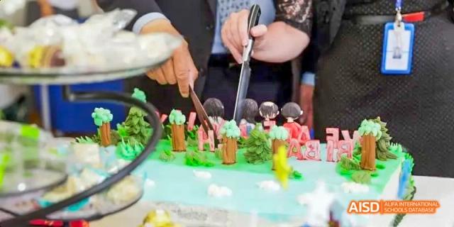 A close-up shot of a person cutting a large, intricately decorated cake at an event at Beijing International Bilingual Academy.