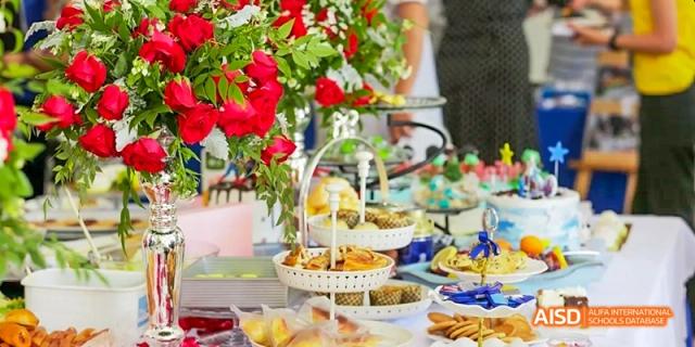 A beautifully arranged table is filled with an assortment of desserts, fruits, and other treats at Beijing International Bilingual Academy.