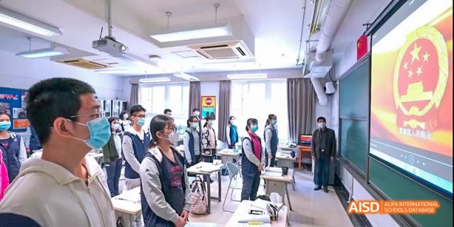 A group of students and teachers from Beijing National Day School International Department gathered in a classroom.