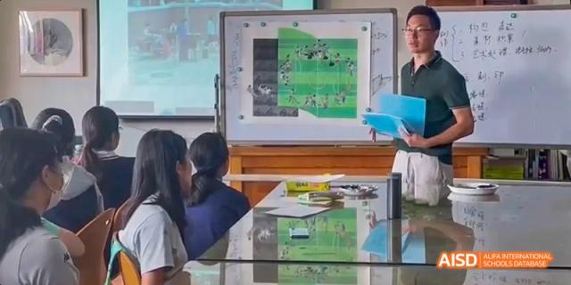 A teacher from Beijing National Day School International Department helping students with a project in a classroom.