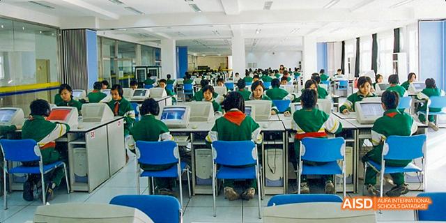 Students from Beijing National Day School International Department studying in a large classroom or study hall.