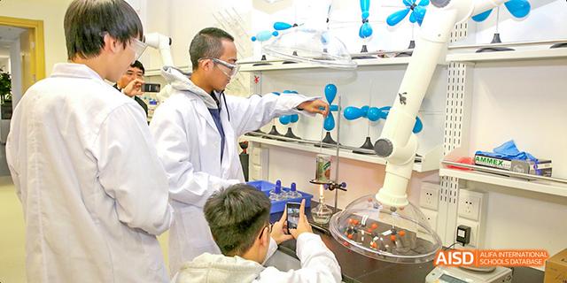 A teacher and a student from Beijing National Day School International Department working on a science experiment in a lab.