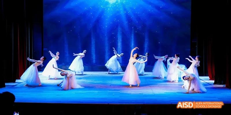 Students from Beijing National Day School International Department performing a dance on a stage.