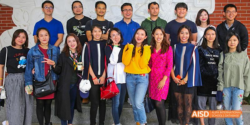 A group of students and faculty from Beijing National Day School International Department posing for a group photo outdoors.