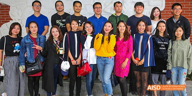 A group of students and faculty from Beijing National Day School International Department posing for a group photo outdoors.