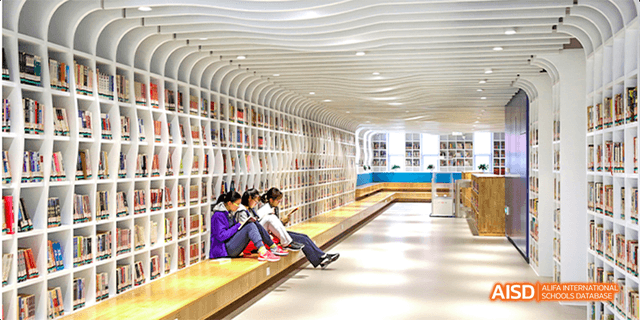 Students from Beijing National Day School International Department reading and studying in a modern, well-lit school library.