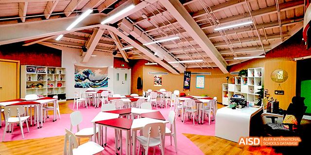 A large, empty event hall with tables and chairs set up for a gathering at Beijing National Day School International Department.