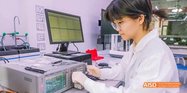 A photo showing a male student in a lab doing a scientific experiment, at Beijing Royal School.