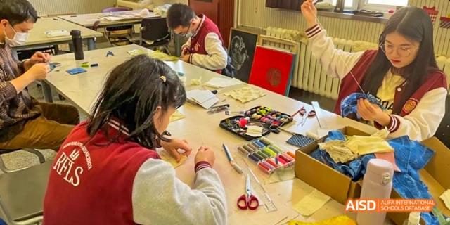 A photo showing students in a classroom doing some kind of craft project, at Beijing Royal School.