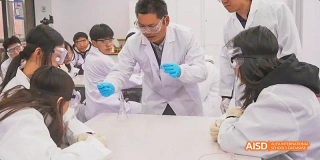 A photo showing a group of students doing a scientific experiment in a lab, at Beijing Royal School.