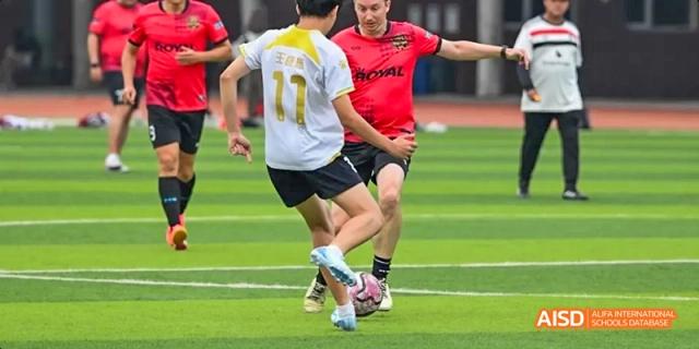A photo showing students playing football in a stadium, at Beijing Royal School.