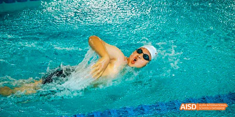 A photo showing a male student participating in a swimming competition, at Beijing Royal School.