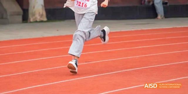 A photo showing a student running on a running track, at Beijing Royal School.