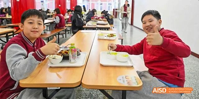 A photo showing a male student eating food with a female student, at Beijing Royal School.