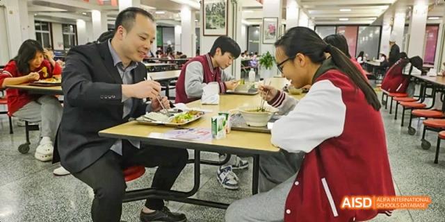 A photo showing a teacher having a discussion with a female student, at Beijing Royal School.