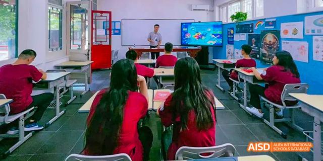 A group of students from Beilu Academy, sitting at desks and using computers in a classroom.