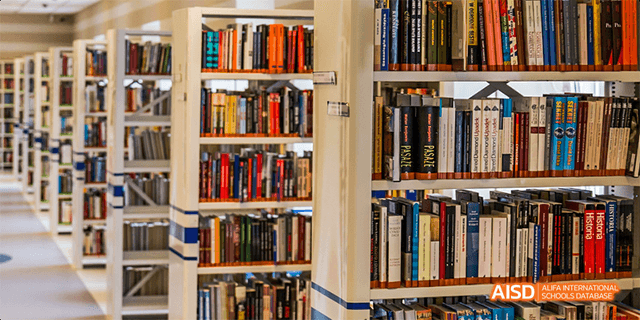 A wide view of bookshelves filled with books in the library at Beilu Academy.