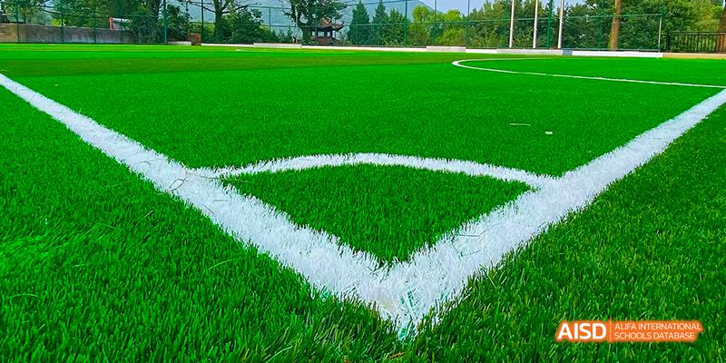 A close-up view of the white lines on the green turf of the sports field at Beilu Academy.