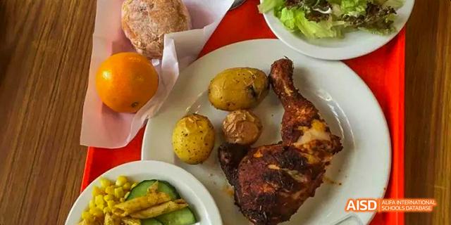 A plate with roasted chicken, potatoes, and a salad, representing a meal served at Beilu Academy.