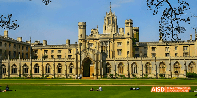 A wide view of a grand university building with a large grassy field in front of it at Beilu Academy.