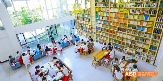 Camford Royal School students studying and reading in a large, modern library.