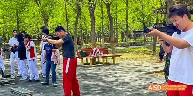 Camford Royal School instructor teaching archery to students at an outdoor camp