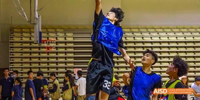 Camford Royal School basketball player attempting a slam dunk in the gymnasium