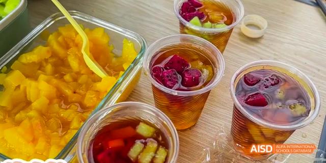 Camford Royal School fruit desserts and drinks served in plastic cups on a wooden table.