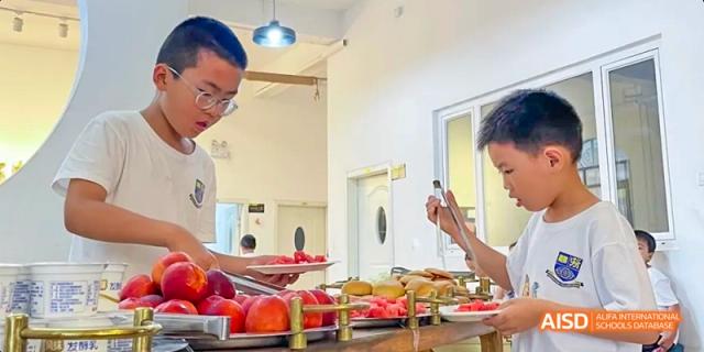 Camford Royal School students preparing and enjoying a meal together indoors.