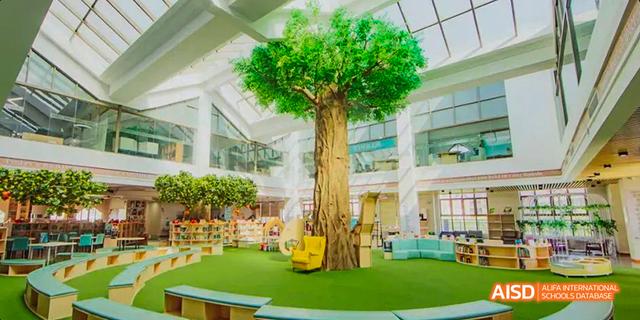 A large, artificial tree stands in an open area inside the Canadian International School of Guangzhou.