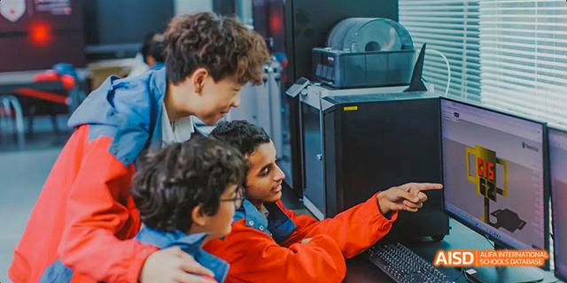 A group of students from the Canadian International School of Guangzhou is working on a computer together.