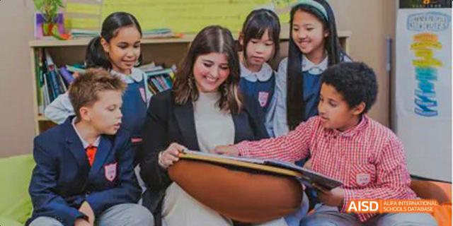 A female teacher from the Canadian International School of Guangzhou is seen helping students with their schoolwork.