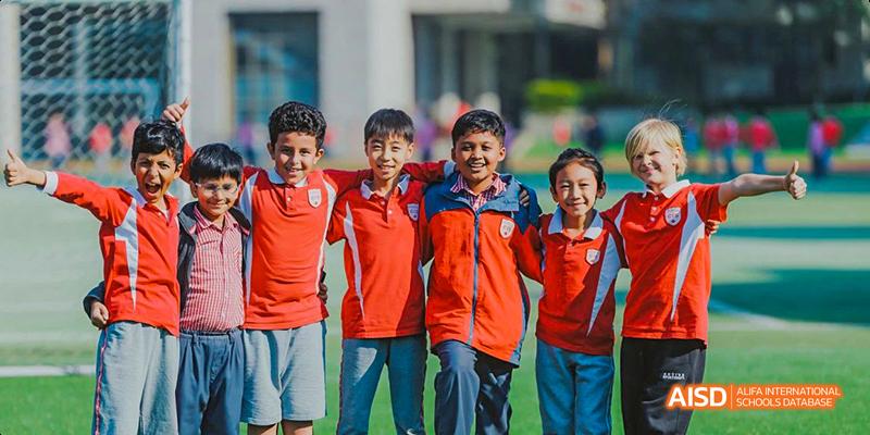A group of young male students from the Canadian International School of Guangzhou smiles together for a group photo.