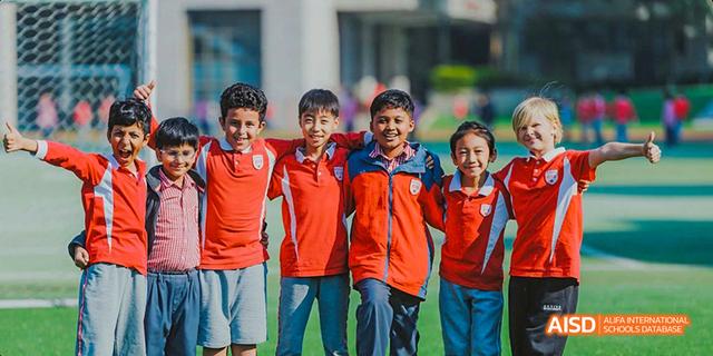 A group of young male students from the Canadian International School of Guangzhou smiles together for a group photo.