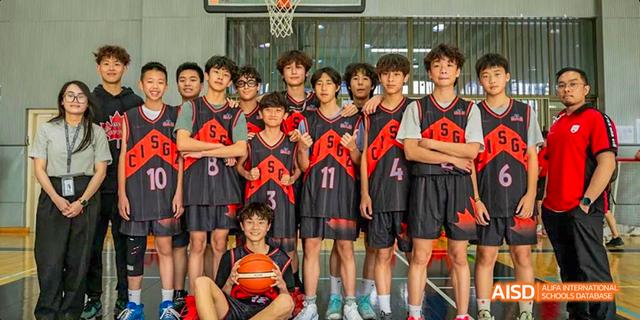 A group of male students from the Canadian International School of Guangzhou, all wearing red and black basketball jerseys, pose together.