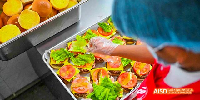 A close-up view of hands preparing sandwiches with fresh vegetables at the Canadian International School of Guangzhou.