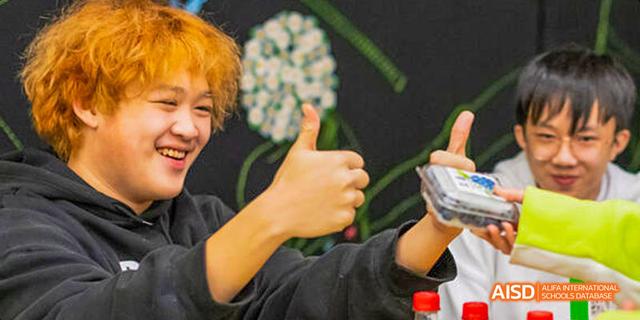 A young person at Dalian American International School giving a thumbs-up.