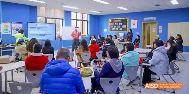 Students sitting in a classroom listening to a teacher at Dipont KCS Chengdu.